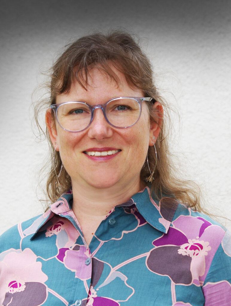 Eine fröhliche Andrea Leitner blickt in die Kamera